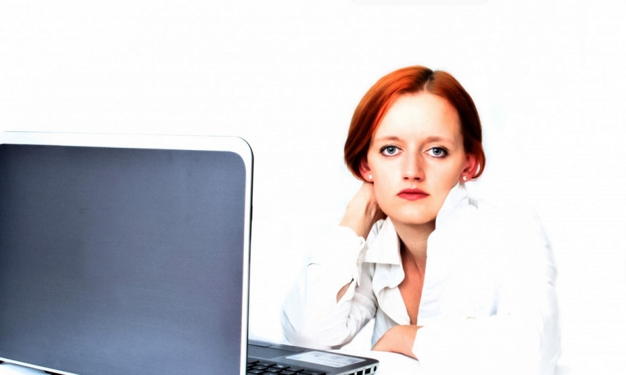 Na zdjęciu młoda kobieta siedząca przed komputerem